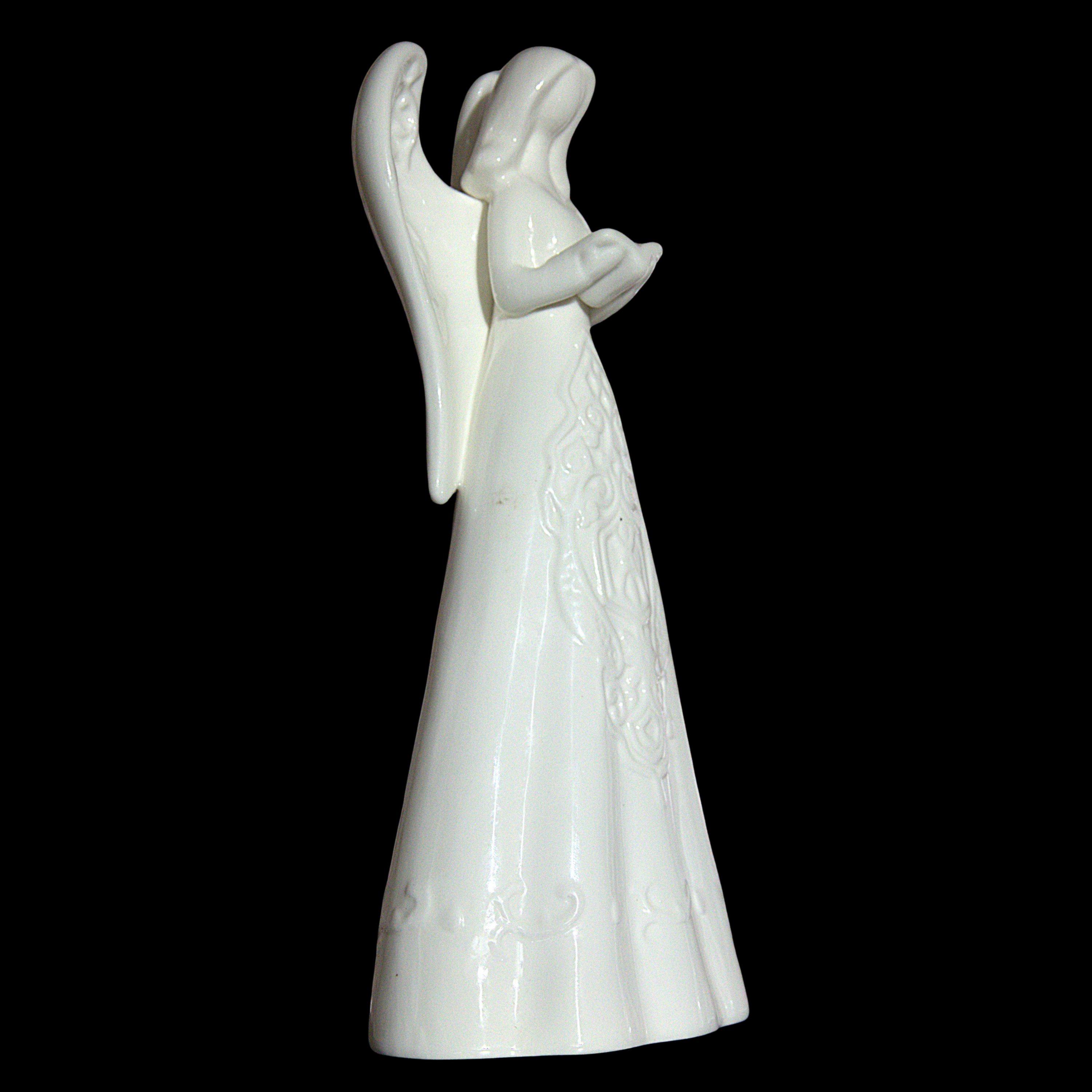 A white ceramic angel figurine with outstretched wings and a long gown, shown against a solid black background.